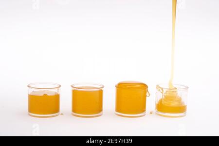 Natürlicher frischer Honig, der in kleine Gläser gefüllt wird. Stockfoto