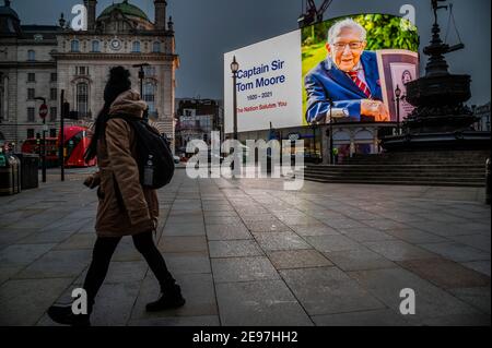 London, Großbritannien. Februar 2021, 3rd. Eine Hommage an den verstorbenen Kapitän Sir Tom Moore auf den Piccadilly Lights - er starb gestern im Alter von 100 Jahren, nachdem er über £30m für den NHS gesammelt. Die dritte „Sperre“ für die Coronavirus-Pandemie (Covid 19) in London wird fortgesetzt. Kredit: Guy Bell/Alamy Live Nachrichten Stockfoto