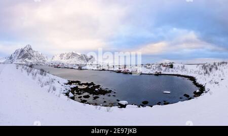 Schönen Dorf Reine Lofoten Inseln, Norwegen. Verschneite Winterlandschaft bei Sonnenuntergang. Erstaunlich Touristenattraktion in den Polarkreis. Panora Stockfoto