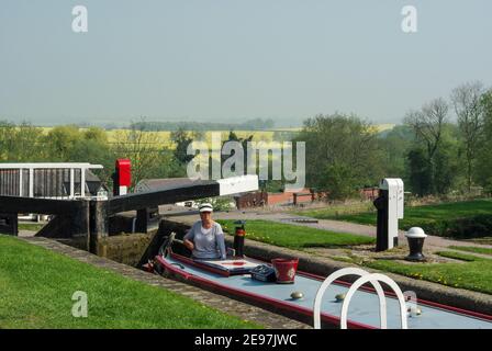 Foxton Schleusen auf dem Grand Union Kanal, Foxton, Leicestershire, Großbritannien; Frau im Schmalboot beim Navigieren des historischen Schleusenfluges. Stockfoto