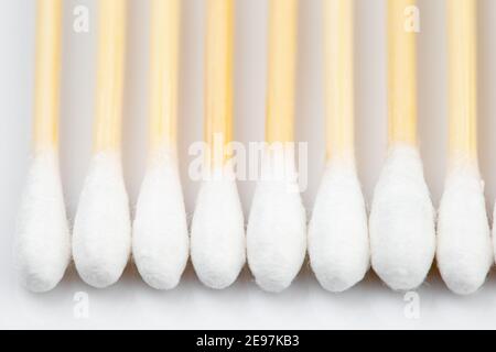 Wattestäbchen aus Holz in einer Reihe auf weißem Hintergrund. Selektiver Fokus Stockfoto