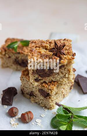 Haferflocken Quadrate mit Schokolade, Nüsse, Stücke von Schokolade und Minze, hellen Beton Hintergrund. Diät-Bars. Gesunde Bäckerei zum Frühstück oder Dessert. Sel Stockfoto