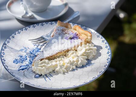 Frische selbst gemachte osterkuchen mit Blumendekoration und Kaffee im Freien. Stockfoto