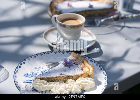 Frische selbst gemachte osterkuchen mit Blumendekoration und Kaffee im Freien. Stockfoto