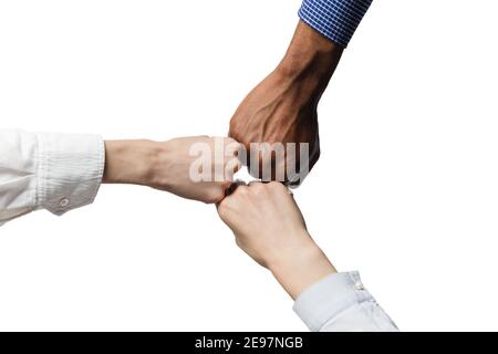 Drei menschliche Hände, die ihre Fäuste als Teamwork, Freundschaftszeichen zusammenlegen. Stockfoto