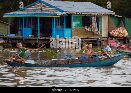 Erkunden Sie das schwimmende Dorf Tonlé SAP See, wo Kinder Unterhalten Sie sich auf Booten Stockfoto