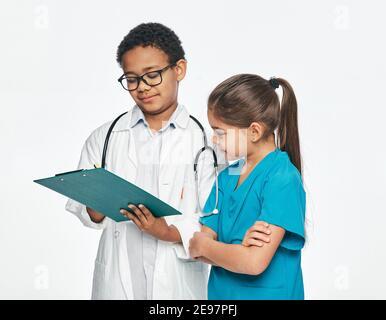 Zwei Kinder spielen medizinisches Personal und wählen einen medizinischen Beruf. Consilium eines Jungen, der Arzt praktiziert, und einer kleinen Krankenschwester Stockfoto