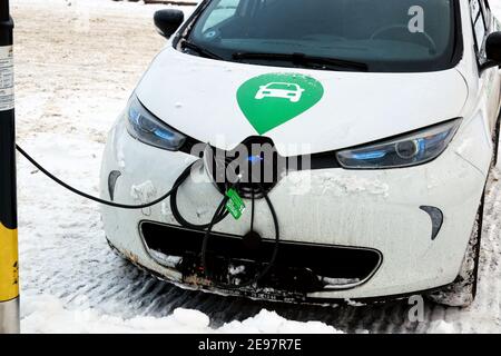 Renault Zoe Elektroauto von Green Mobility lädt die Batterie an einer öffentlichen Ladestation. Helsinki, Finnland. Februar 2, 2021. Stockfoto