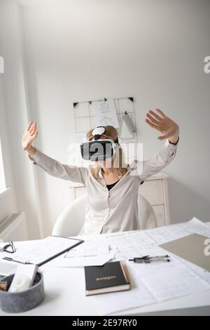 Schöne junge Architektin mit Virtual-Reality-Brille in ihr Büro Stockfoto