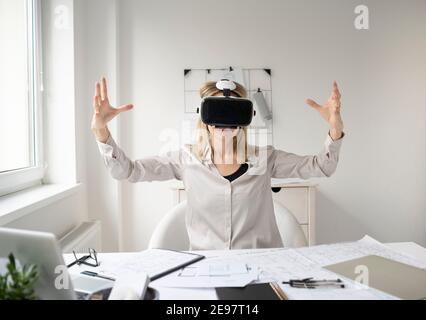 Schöne junge Architektin mit Virtual-Reality-Brille in ihr Büro Stockfoto
