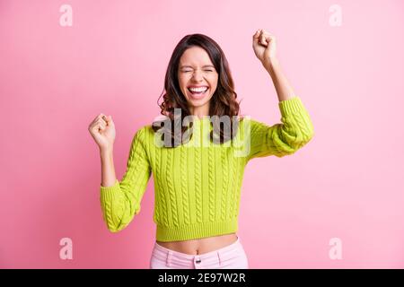 Foto von liebenswert glücklich wellig Dame tragen grünen Pullover steigt Fäuste geschlossenen Augen isoliert pastellrosa Hintergrund Stockfoto