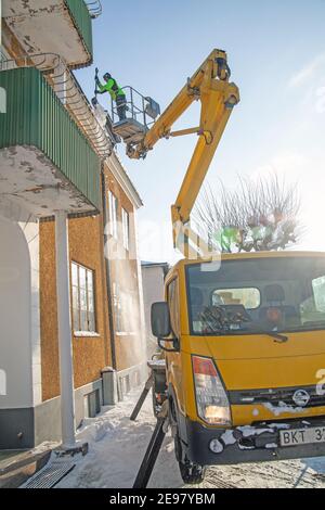 Arbeiter auf Sky Lift Entfernen von Dachschnee in Malmkoping. Foto: Bo Arrhed Stockfoto