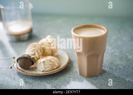 Ein Getränk in einem Keramikglas und ein Kuchen auf dem Tisch. Gutes Frühstück. Stockfoto