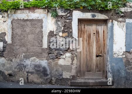 Alte Holztüren in einem baufälligen Steingebäude. Stockfoto