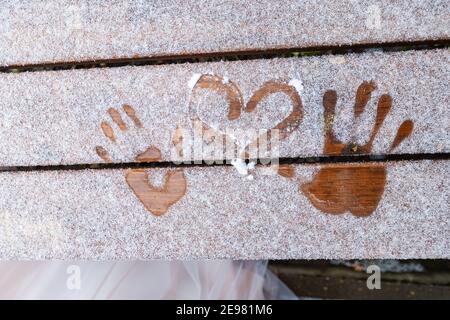 Zwei Liebende ziehen mit den Fingern in den Schnee, ziehen Herzen in den Schnee, eine süße und berührende Unterhaltung für das Brautpaar Stockfoto