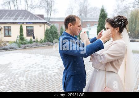 Menschen tragen medizinische Masken zueinander, sorgen für die Gesundheit eines geliebten Menschen während einer Pandemie, Sicherheit und Hygiene in einer Schutzmaske und Handschuhen Stockfoto