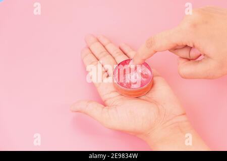 Frau mit Petroleum Gelee auf rosa Hintergrund Stockfoto