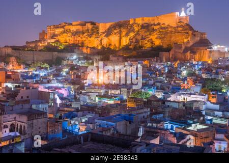 Blick auf das beleuchtete Mehrangarh-Fort von einem Dach in der Blauen Stadt bei Einbruch der Dunkelheit, Jodhpur, Rajasthan, Indien Stockfoto