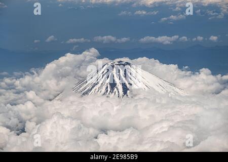 Mt. Fuji bedeckt mit Schnee und Wolken darunter. Luftaufnahme. Stockfoto