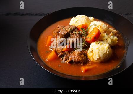 Food Concept Spot fosuc hausgemachter klassischer Rindereintopf mit Kartoffelpüree Kartoffel in schwarzer Schale mit Kopierer Platz Stockfoto