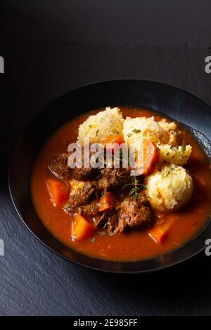 Food Concept Spot fosuc hausgemachter klassischer Rindereintopf mit Kartoffelpüree Kartoffel in schwarzer Schale mit Kopierer Platz Stockfoto