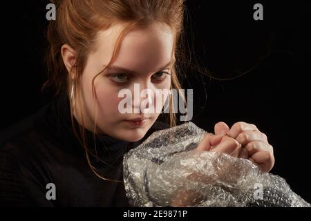 Gestresste Frau in Depression platzt Blasen der Verpackung Cellophan Stockfoto