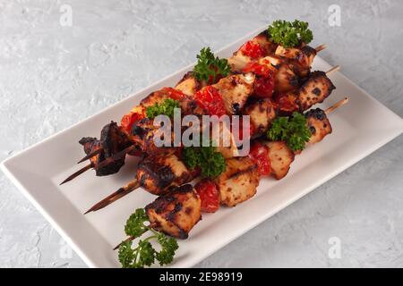 Auf einem grauen Hintergrund Grill von Huhn auf Spieße mit Gemüse Stockfoto