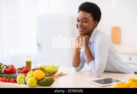 Schwarze Frau Posiert In Küche Stehend Neben Tisch Zu Hause Stockfoto