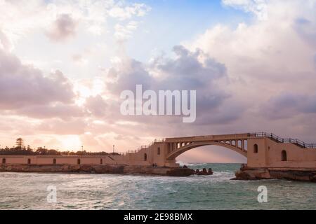 Alexandria, Ägypten. Küstenlandschaft mit Montazah-Brücke unter bunt bewölktem Himmel Stockfoto