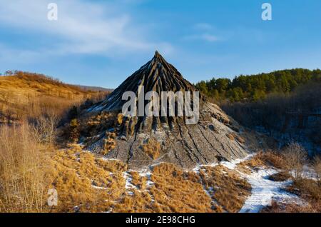 Erstaunliche Luftaufnahme von verlassenen Schlackenhaufen bedeckt von Schnee und Gras, Winterlandschaft. Der ungarische Name ist zagyvarónai salakkúp. Stockfoto