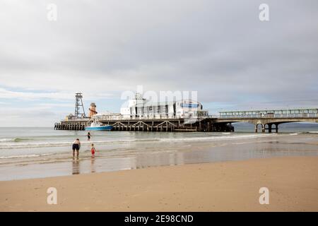 Paddler im Wasser am Strand am Bournemouth Pier, Dorset Stockfoto