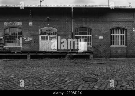 Die Verladerampe eines alten Lagerhauses, Verladerampe und ein Schiebetor eines alten Lagerhauses, schwarz-weiß Foto Stockfoto