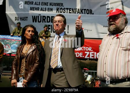 SPD-Vorsitzender Franz Müntefering hat sich dem marsch der 1. Mai-Kundgebung des Deutschen Gewerkschaftsbundes angeschlossen. Ziel der Prozession ist der Landschaftspark Nord in Duisburg, wo er inmitten heftiger Proteste aus dem Publikum sprach. Fliegende Eier wurden von Polizeibeamten mit ihren Schilden abgestoßen. Müntefering macht dann einen Rundgang durch die Stände der Gewerkschaftsgruppen, wo er mit einigen Genossen ein Bier trinkt. Stockfoto