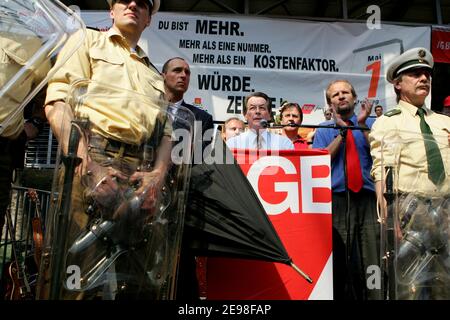 SPD-Vorsitzender Franz Müntefering hat sich dem marsch der 1. Mai-Kundgebung des Deutschen Gewerkschaftsbundes angeschlossen. Ziel der Prozession ist der Landschaftspark Nord in Duisburg, wo er inmitten heftiger Proteste aus dem Publikum sprach. Fliegende Eier wurden von Polizeibeamten mit ihren Schilden abgestoßen. Müntefering macht dann einen Rundgang durch die Stände der Gewerkschaftsgruppen, wo er mit einigen Genossen ein Bier trinkt. Stockfoto