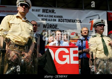 SPD-Vorsitzender Franz Müntefering hat sich dem marsch der 1. Mai-Kundgebung des Deutschen Gewerkschaftsbundes angeschlossen. Ziel der Prozession ist der Landschaftspark Nord in Duisburg, wo er inmitten heftiger Proteste aus dem Publikum sprach. Fliegende Eier wurden von Polizeibeamten mit ihren Schilden abgestoßen. Müntefering macht dann einen Rundgang durch die Stände der Gewerkschaftsgruppen, wo er mit einigen Genossen ein Bier trinkt. Stockfoto