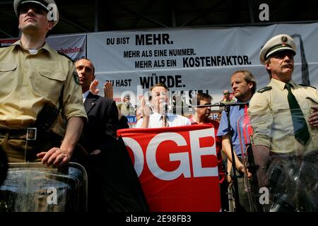 SPD-Vorsitzender Franz Müntefering hat sich dem marsch der 1. Mai-Kundgebung des Deutschen Gewerkschaftsbundes angeschlossen. Ziel der Prozession ist der Landschaftspark Nord in Duisburg, wo er inmitten heftiger Proteste aus dem Publikum sprach. Fliegende Eier wurden von Polizeibeamten mit ihren Schilden abgestoßen. Müntefering macht dann einen Rundgang durch die Stände der Gewerkschaftsgruppen, wo er mit einigen Genossen ein Bier trinkt. Stockfoto