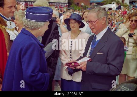 John Burton vom Winkle Club überreicht Queen Elizabeth II eine goldene Winkle Brosche und Ehrenmitgliedschaft im Winkle Club. Hastings Old Town, East Sussex, England, Großbritannien. 6th. Juni 1997 Stockfoto