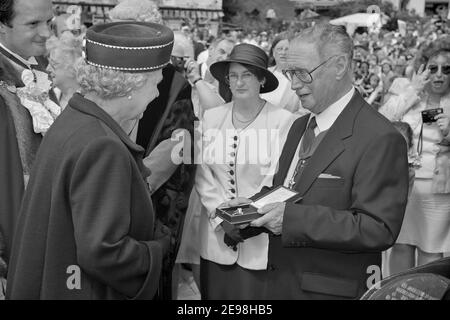 John Burton vom Winkle Club überreicht Queen Elizabeth II eine goldene Winkle Brosche und Ehrenmitgliedschaft im Winkle Club. Hastings Old Town, East Sussex, England, Großbritannien. 6th. Juni 1997 Stockfoto