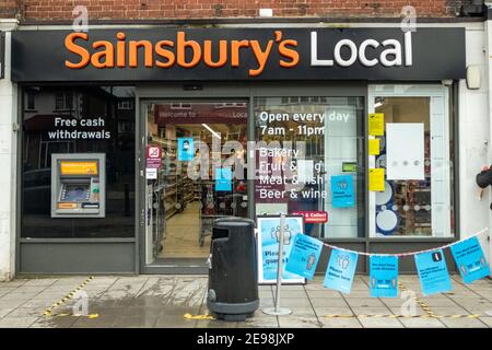 London - Sainsburys lokales Geschäft in Acton, West London mit Covid 19 Beschilderung und Warteschlangenbereich Stockfoto