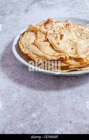 Stapel frischer französischer Crepes (auch als Pfannkuchen bekannt) auf einem großen Teller. Stockfoto