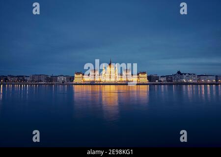 Spiegelung des beleuchteten ungarischen Parlamentsgebäudes in der Donau. Budapest Skyline in der Abenddämmerung, Ungarn. Stockfoto