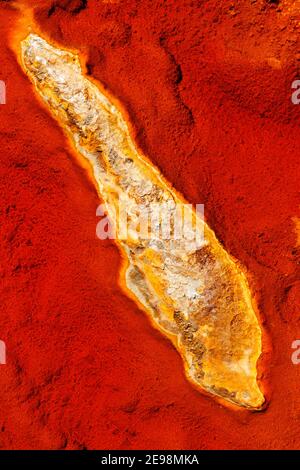 Abstrakte Texturen und Formationen am Ufer des Rio Tinto Flusses, Andalusien Spanien. Schattierungen von Rot und Orange, Eisen und andere Mineralien im Wasser. Stockfoto