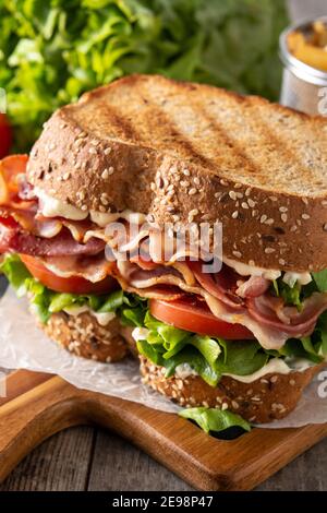 BLT-Sandwich und Pommes auf Holztisch Stockfoto