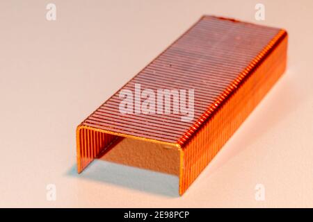Kopierte Heftklammern, Nahaufnahme in Weißtönen. Gruppe von Kupfer Heftklammern diagonal platziert, als ob es ein Tunnel mit dem Licht aus beh Stockfoto