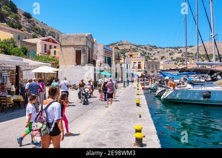 Tourist auf einer Promenade in der Hauptstadt der Insel Symi. Griechenland Stockfoto