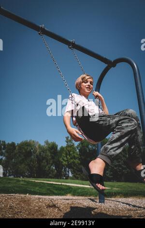 Happy Boy auf Swing an einem sonnigen Nachmittag Stockfoto