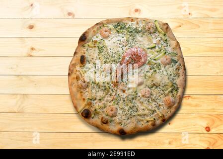 Pizza mit Garnelen und Zucchini und Käse auf Holzhintergrund in Draufsicht flach legen, Kopierraum Stockfoto