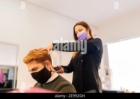 Friseur Schneiden Haare mit Rasiermesser zu jungen Mann Stockfoto