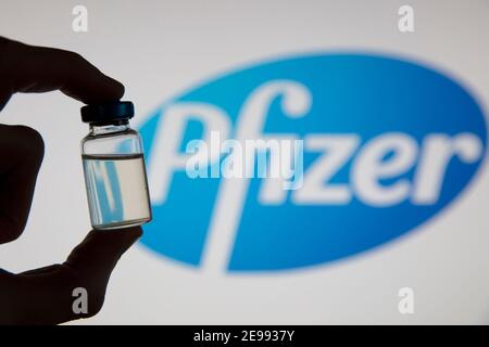 OXFORD, Großbritannien - Februar 2020: Eine kovidierte Impfstoffflasche vor dem pfizer-Logo Stockfoto