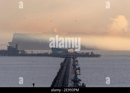 Southend on Sea, Essex, Großbritannien. Februar 2021, 3rd. HMM Le Havre wird gesehen, wie er am späten Nachmittag am Pier von Southend am Sea an der Themse-Mündung vorbeifährt und nach dem Verlassen des DP World London Gateway Hafens in Nebel verschwindet. Das Containerschiff der Algeciras-Klasse ist eines der größten jemals gebauten Schiffe, das im August 2020 in Dienst gestellt wurde und fast 24000 Container befördern kann. Es bedient die Route Fernost-Europa 3. Das Vereinigte Königreich bewirbt sich um den Beitritt zum umfassenden und progressiven Abkommen über die Transpazifische Partnerschaft (CPTPP), zu dem auch fernöstliche Länder gehören, die von riesigen Schiffen wie diesem bedient werden Stockfoto